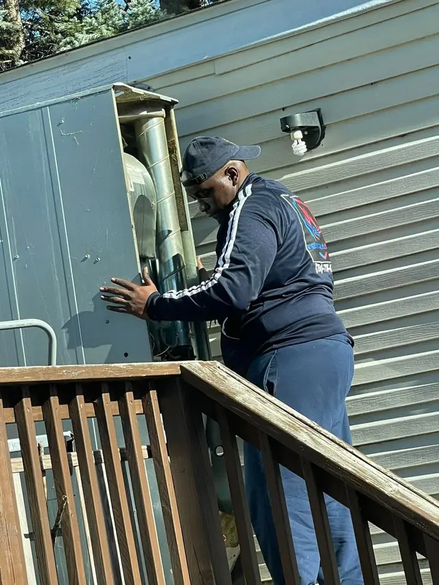 Al from Temprasure on a wooden deck with the panel open on a package unit