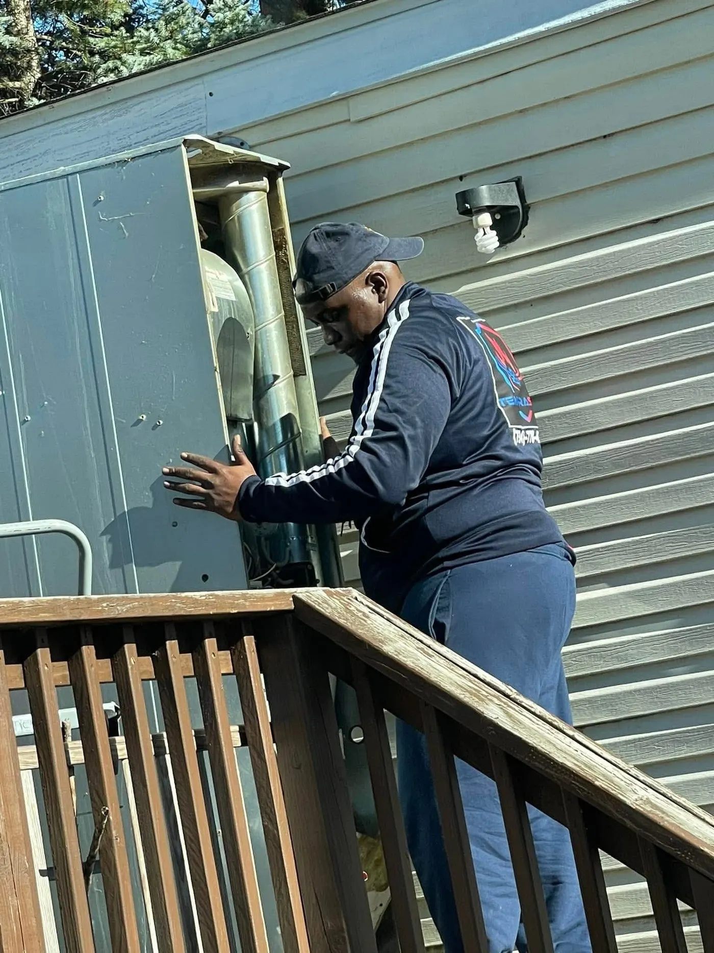 Al from Temprasure on a wooden deck with the panel open on a package unit