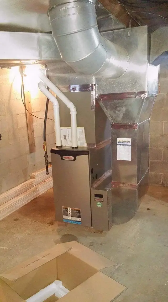 A Lennox high-efficiency furnace with PVC intake and exhaust and new sheet-metal supply ductwork in a block basement