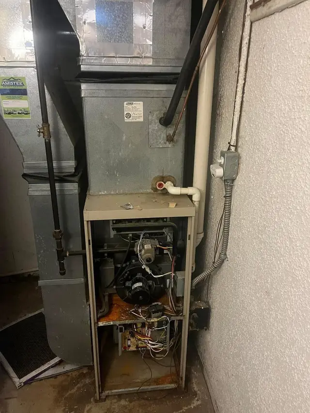 An older Lennox furnace with the panel off, showing the inducer motor, gas valve and control board